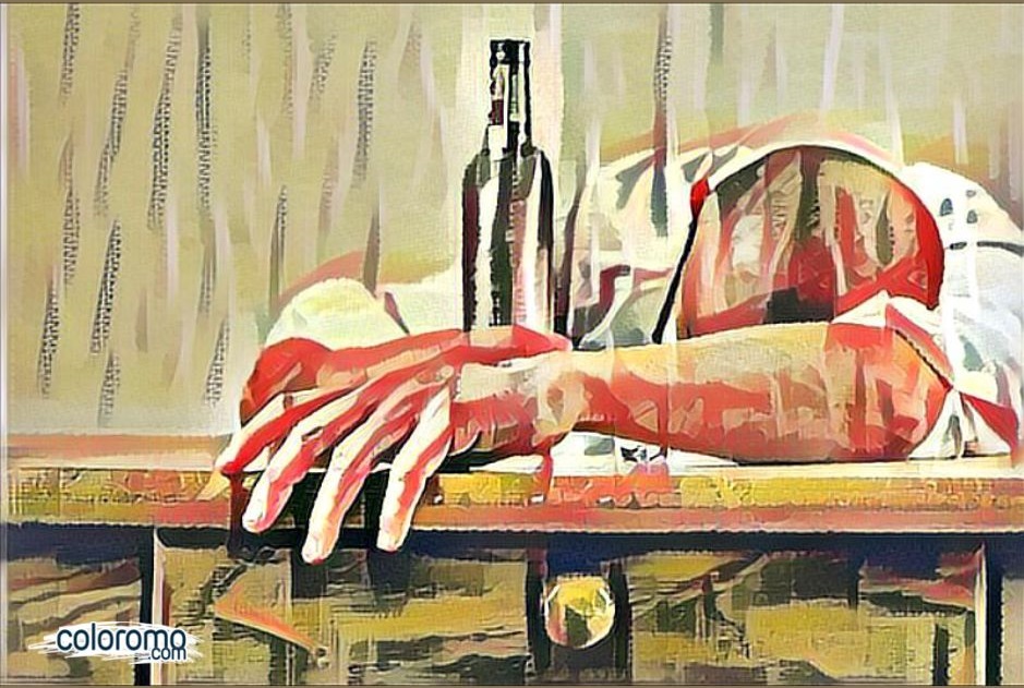 man laying head on bar with bottle